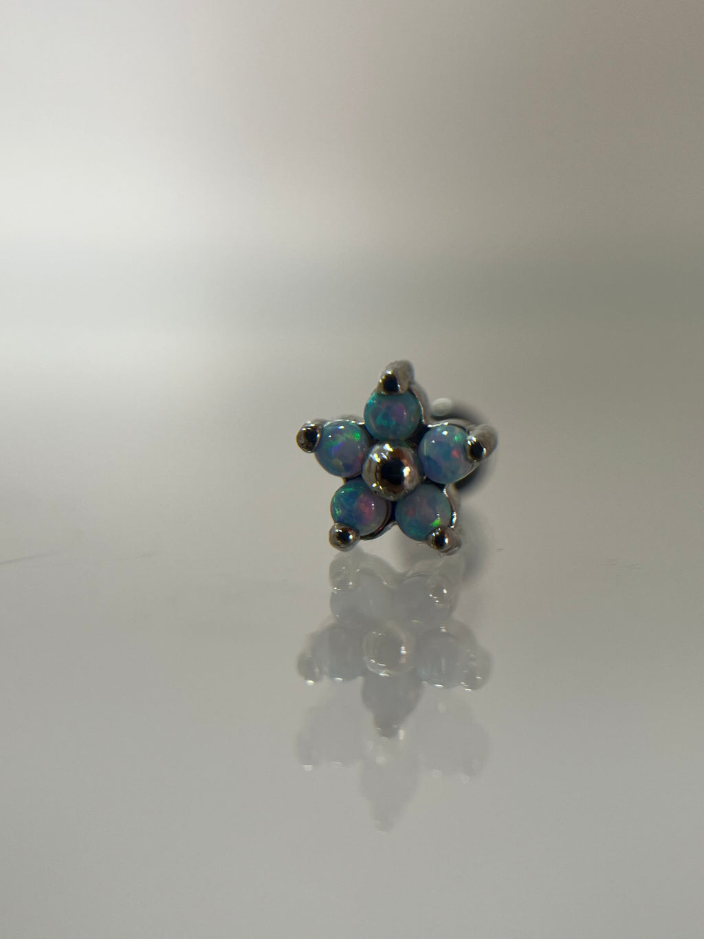 Piercing flor azul acero plateado (cierre plano)