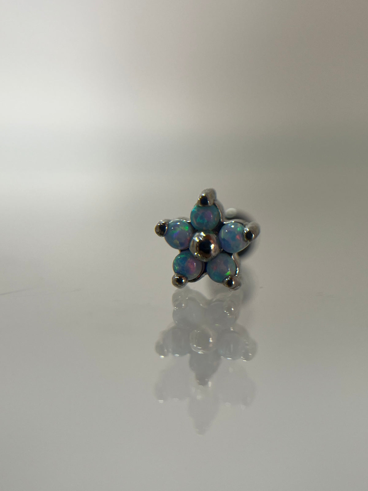 Piercing flor azul acero plateado (cierre plano)