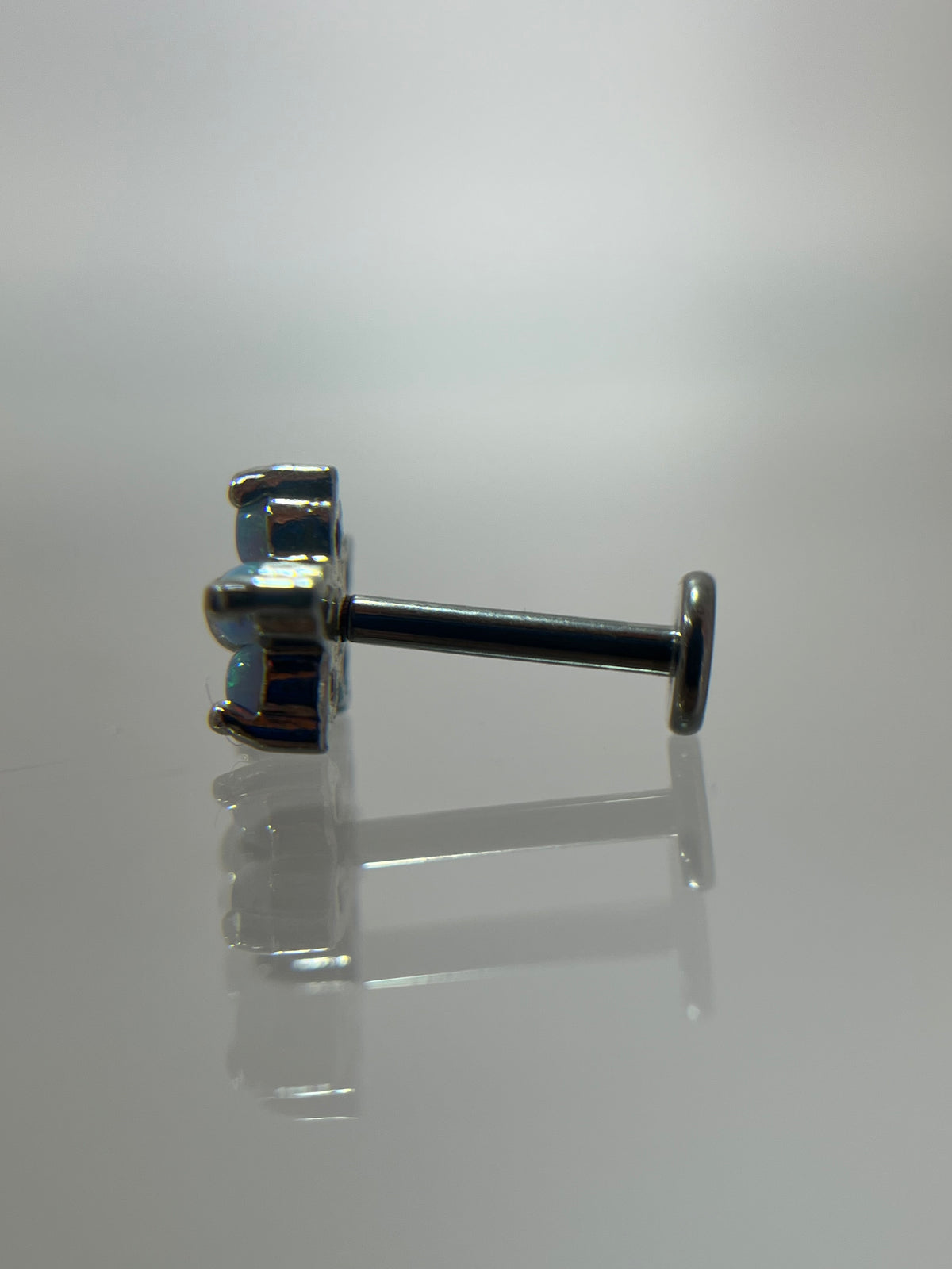 Piercing flor azul acero plateado (cierre plano)